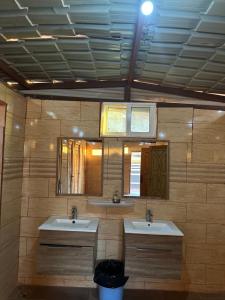 Un baño con dos lavabos y un espejo. en Desert Star Camp, en Wadi Rum