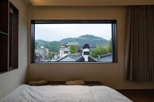 a bedroom with a large window with a view at Cocoa House in Jeonju