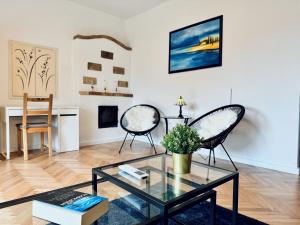 a living room with two chairs and a glass table at Csodakertes kisház Balatonfűzfőn in Balatonfůzfő