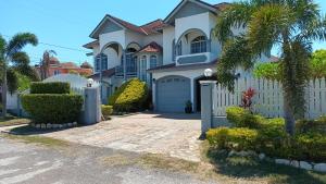 a house with a white fence and a driveway at Sukasa Ville in Montego Bay