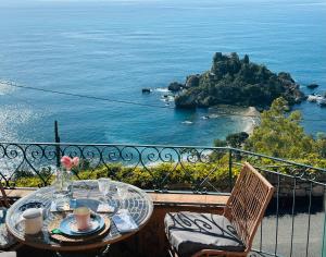 a table and chairs with a view of the ocean at La Bergerie Isolabella sea view B & B in Taormina