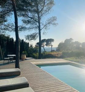 a swimming pool on a wooden deck with a table at Le Cigalon in Le Beausset +17 photos