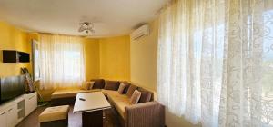 una sala de estar con un sofá y una mesa en Апартамент Литов, en Sandanski