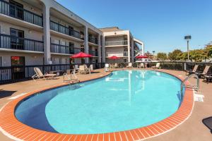 una piscina en un hotel con mesas y sillas en Clarion Pointe Huntsville Research Park, en Huntsville