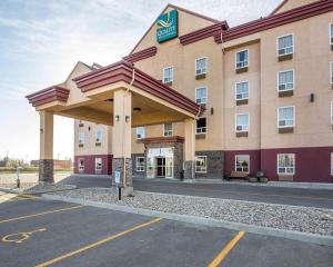 een hotel met een groot gebouw met een parkeerplaats bij Quality Inn & Suites in Lethbridge