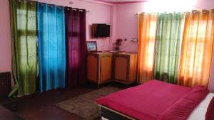 a room with rainbow colored curtains and a bed at Hotel bhagirathi darshan in Jāmb