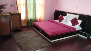 a bedroom with a bed with a red blanket at Hotel bhagirathi darshan in Jāmb