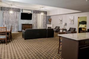 a living room with a couch and a table at Evangeline Downs Hotel, an Ascend Collection Hotel in Opelousas