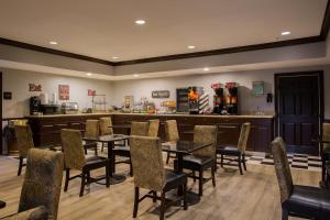 a restaurant with tables and chairs and a bar at Evangeline Downs Hotel, an Ascend Collection Hotel in Opelousas
