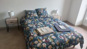 a bedroom with a bed with a colorful comforter and two lamps at chez Marie et Xav in Frasne-les-Meulières