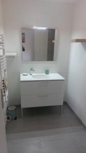 a white bathroom with a sink and a mirror at chez Marie et Xav in Frasne-les-Meulières