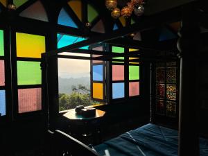 a room with a window with a view of a mountain at Room Marakkech Mazha at Samara Farms Calicut in Kozhikode