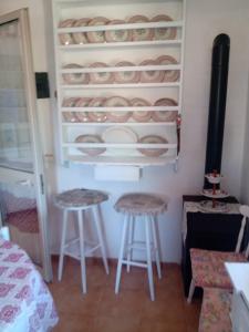 a room with two stools and plates in a refrigerator at Gioia House in Rome