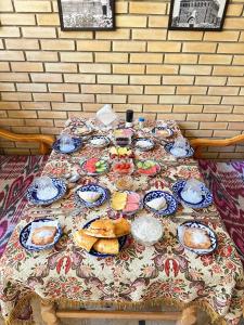 a table with plates of food on it at Hotel Mironshox in Bukhara