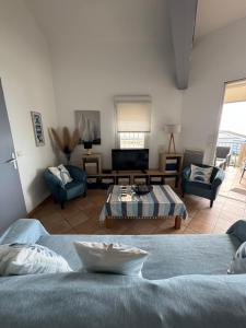 グリュイッサンにあるLe Soleil Levantのベッド2台とソファのあるリビングルーム