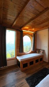 a bedroom with a bed with a large window at Cabin by The Woods - Mukteshwar - Nature - Romantic - Secluded in Mukteswar