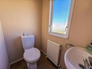 a bathroom with a toilet and a sink and a window at Modern 6 Berth Caravan With Free Wifi Nearby Pakefield Beach Ref 68028Cr in Lowestoft +12 photos