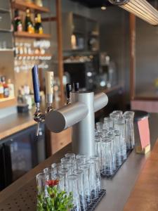 a row of empty glasses sitting on a counter at 1851 Bar - Hotel - Cinema in Wijk bij Duurstede