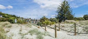 ネルソンにあるThe Sands Beach Apartmentの塀と木のある砂浜