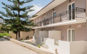 a building with a tree in front of it at Nikos & Maria Studios II in Laganas