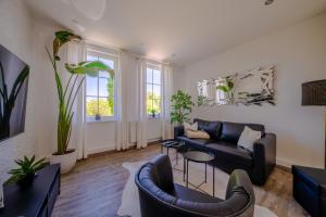 a living room with a black leather couch and chairs at Aurora Schaar 1, 120qm, WiFi, Maisonette, Modern,2 Schlafzimmer, 1 Wohnzimmer in Wilhelmshaven