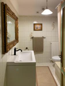 a white bathroom with a sink and a toilet at Santa Maria apartments in Todi