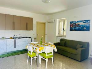 a kitchen and a living room with a table and a couch at Casa Vacanza Aria di Mare in Policoro