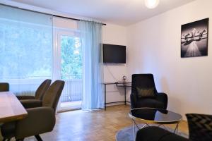 a living room with chairs and a table and a window at Stilvolle 2 Schlafzimmer Apartments Heidegarten, Osterheide, Zentrum in Schneverdingen