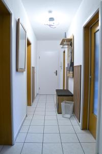 a corridor of a hospital hallway with a white tile floor at Stilvolle 2 Schlafzimmer Apartments Heidegarten, Osterheide, Zentrum in Schneverdingen +42 photos