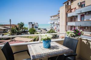 un tavolo e sedie su un balcone con vista sull'oceano di le Notti di Morfeo a San Leone