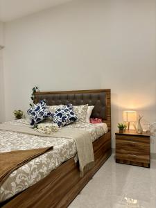 a bedroom with a large bed with blue and white pillows at Vibrant 2 BHK Apartment Near Airport in Mumbai