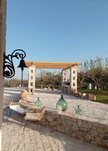 a stone wall with chairs and green glass vases at Trulli Fortunato private, heated swimming pool in Locorotondo