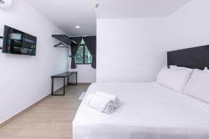 a bedroom with a white bed and a desk at E Hotel Kulim in Kulim +22 photos