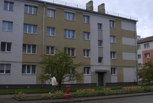 a man walking in front of a building at Black Pearl Luxury Apartment in Ventspils