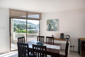 a dining room with a table and chairs and a window at Le Roc 10 in Ballito