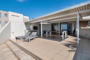 a patio with benches and a table on a house at Le Roc 10 in Ballito