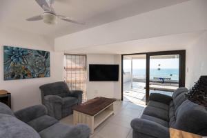 a living room with a couch and chairs and a tv at Le Roc 10 in Ballito
