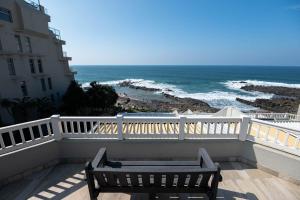 a bench sitting on a balcony looking at the ocean at Le Roc 10 in Ballito