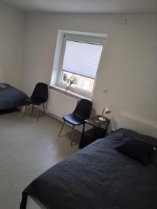 a bedroom with a bed and two chairs and a window at JoPit Haus in Baesweiler