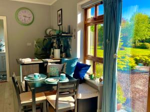 uma sala de jantar com mesa e cadeiras e uma janela em The Conifers Studio Apartment With Private Garden em Wexford