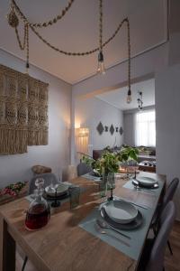 a dining room with a wooden table with plates on it at THE RUSTICK HOUSE - TRIKALA near the elf mill in Tríkala