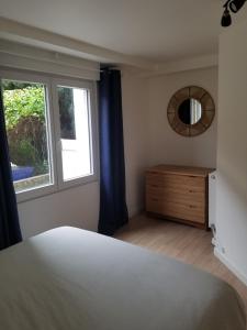 a bedroom with a bed and a window and a dresser at appartement cosy avec jardin Amboise in Amboise