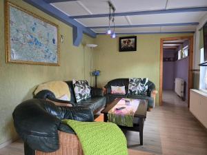 a living room with two leather couches and a table at Ferienhaus ODIN in Großräschen