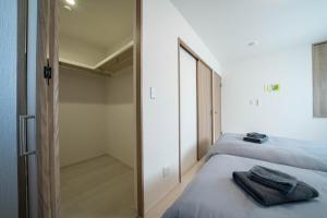 a bedroom with two beds and a door to a closet at Lumiere Vista in Sapporo