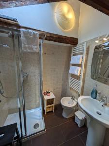 Un baño con ducha, lavabo e inodoro. en Attico Sospiri, en Venecia 36 fotos más