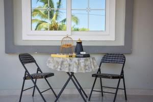 two chairs and a table with a bird cage on it at Tongue Villa in Bungi