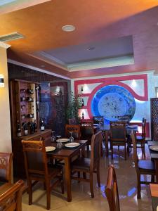 a dining room with tables and chairs and a mural at Hotel Besa in Shëngjin