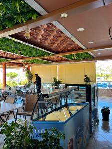 a restaurant with tables and chairs and plants at Hotel Besa in Shëngjin