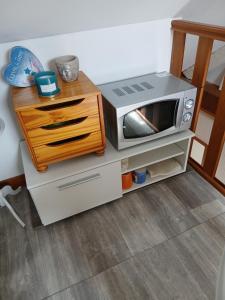 a microwave on a stand with a wooden drawer at Chambre sérénité in Moult