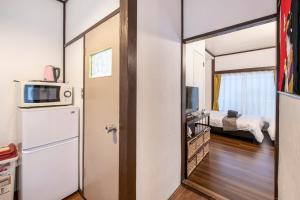 a small room with a refrigerator and a bed at Central Panda Hotel in Tokyo